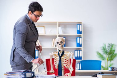 İskeletle çalışan bir iş adamı.