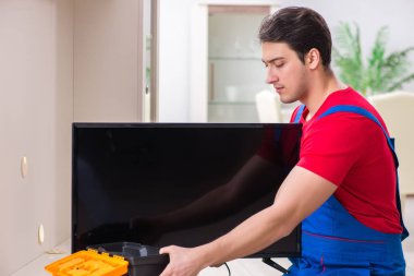Profesyonel tamir mühendisi bozuk televizyonu tamir ediyor.
