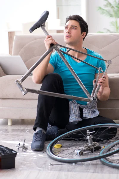 Joven reparando bicicleta en casa —  Fotos de Stock