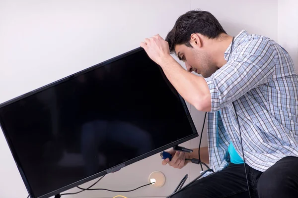 Man repairing broken tv at home