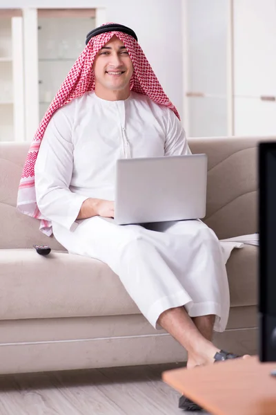 Arab man watching tv at home