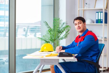 Foreman inşaat planına bakıyor.