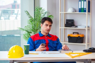 Foreman inşaat planına bakıyor.