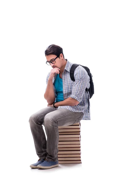 Joven estudiante sentado en la parte superior de la pila de libros en blanco — Foto de Stock