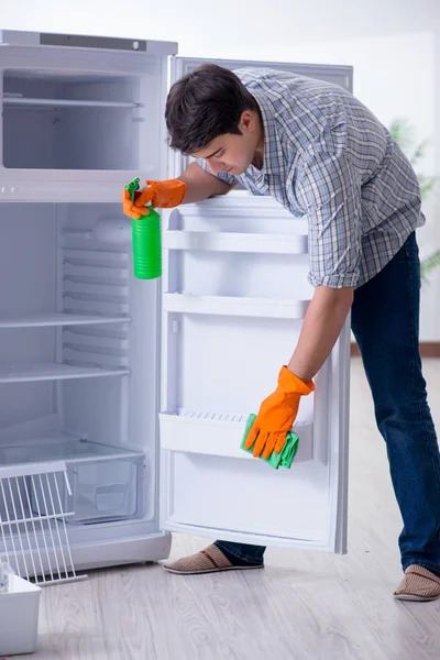 Hombre limpieza nevera en concepto de higiene — Foto de Stock