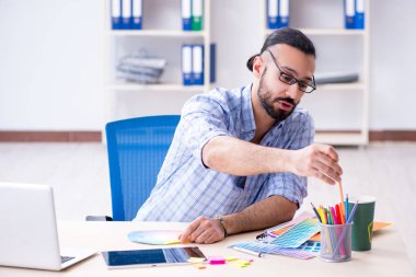 Genç tasarımcı stüdyosunda yeni bir proje üzerinde çalışıyor.