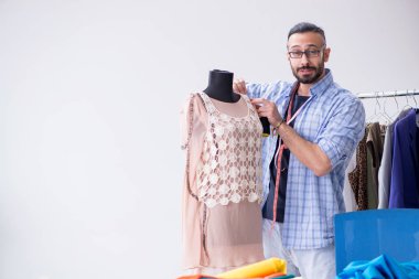 Yeni tasarımlar üzerinde çalışan erkek terzi.