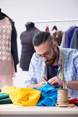 Yeni tasarımlar üzerinde çalışan erkek terzi.