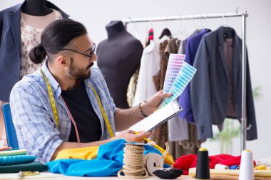 Yeni tasarımlar üzerinde çalışan erkek terzi.