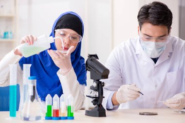 Laboratuvarda çalışan iki kimyager.
