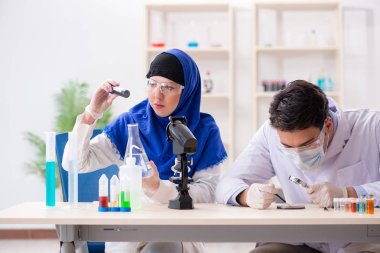 Laboratuvarda çalışan iki kimyager.