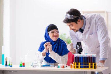 Laboratuvarda çalışan iki kimyager.