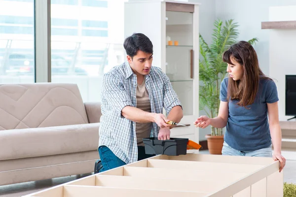 Young family assembling furniture at new house — Stock Photo, Image