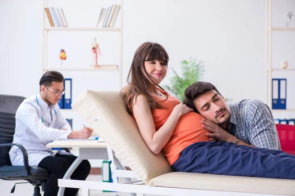 Donna incinta con il marito in visita dal medico in clinica — Foto Stock