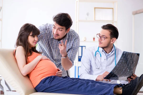 Mulher grávida com o marido visitando o médico na clínica — Fotografia de Stock