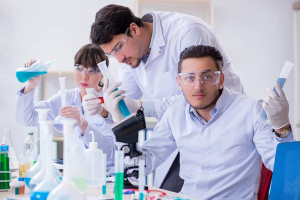 Equipe de químicos que trabalham no laboratório — Fotografia de Stock