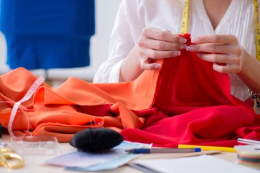 Yeni elbise tasarımları üzerinde çalışan kadın terzi.