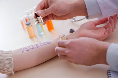 Hastanedeki hastanın alerji reaksiyonunu test eden doktor.