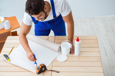 Tadilat sırasında duvar kâğıdı üzerinde çalışan işçiler