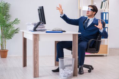 Çalışan ofiste sanal gerçeklik gözlüğü kullanıyor.