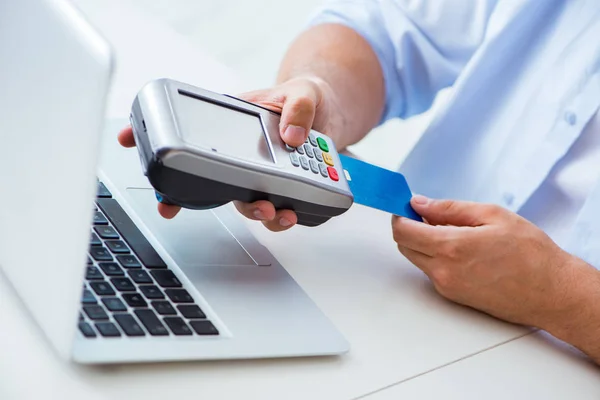 Man processing credit card transaction with POS terminal