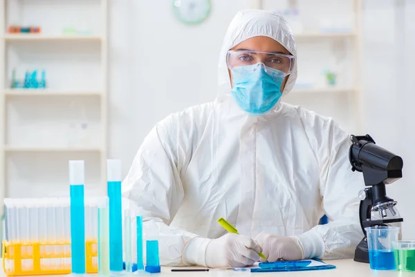 Jovem estudante de química que trabalha em laboratório em produtos químicos — Fotografia de Stock