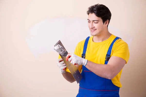 Empleado joven contratista aplicando yeso en la pared — Foto de Stock