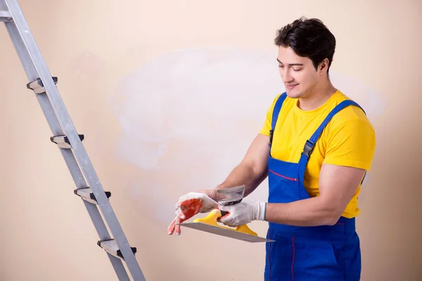 Junger Bauunternehmer verputzt Wand — Stockfoto