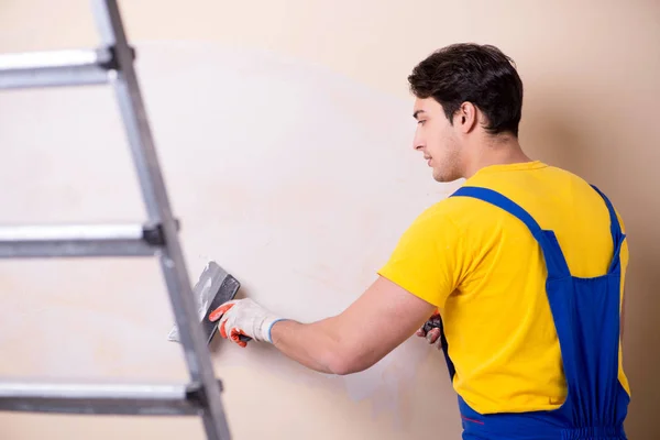 Empregado jovem empreiteiro aplicando gesso na parede — Fotografia de Stock