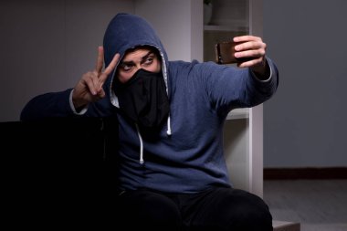 Hırsız, apartmandan televizyon çalıyor.