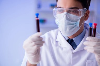 Laboratuvar asistanı hastanede kan örneklerini test ediyor.