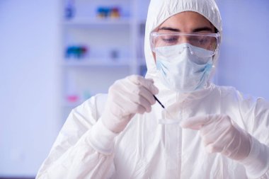 Laboratuvar asistanı hastanede kan örneklerini test ediyor.