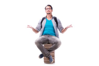 Beyaz kitap yığın üstüne oturan genç öğrenci