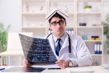 Genç doktor klinikteki röntgen görüntülerine bakıyor.