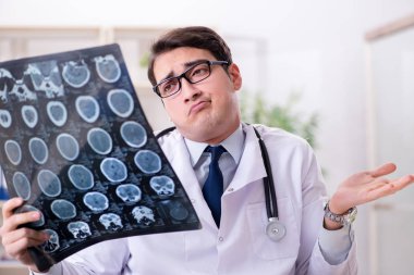 Genç doktor klinikteki röntgen görüntülerine bakıyor.