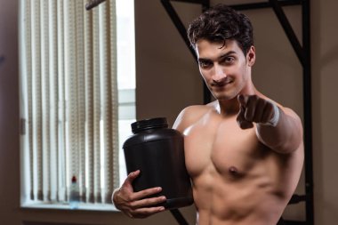Spor salonunda besin takviyesi olan bir adam.