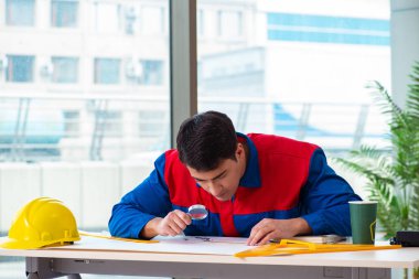 Foreman inşaat planına bakıyor.