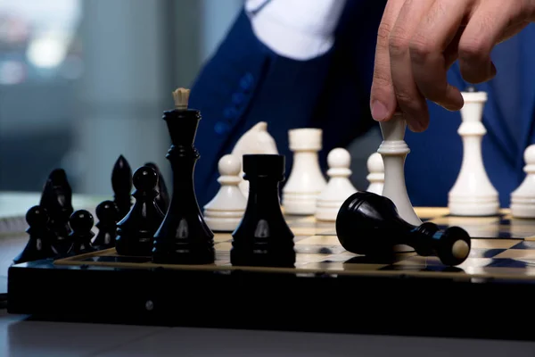 Businessman playing chess in strategy concept — Stock Photo, Image