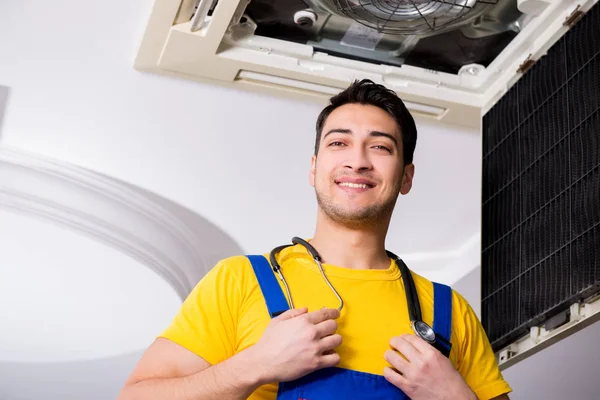 Repairman repairing ceiling air conditioning unit — Stock Photo, Image