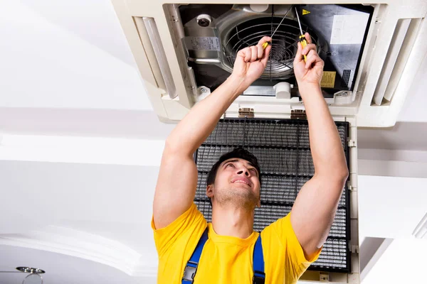 Reparador reparando la unidad de aire acondicionado del techo — Foto de Stock