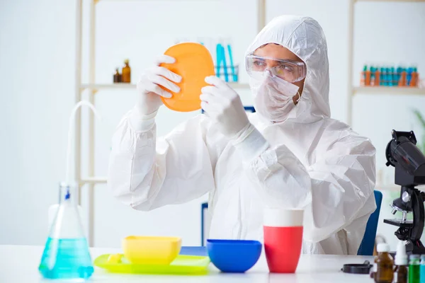 Chemist checking and testing plastic dishes