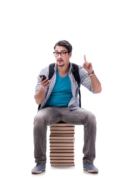 Joven estudiante sentado en la parte superior de la pila de libros en blanco — Foto de Stock