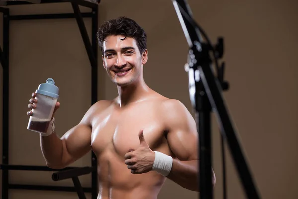 Muž s doplňky živin ve sportovní tělocvičně — Stock fotografie