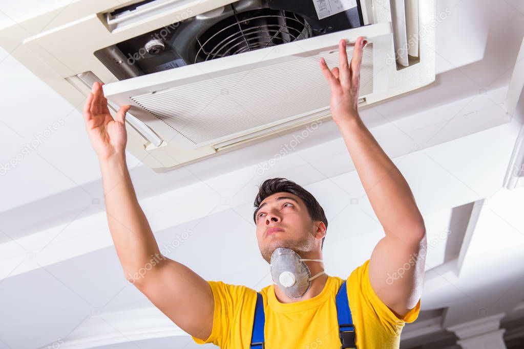 Repairman repairing ceiling air conditioning unit