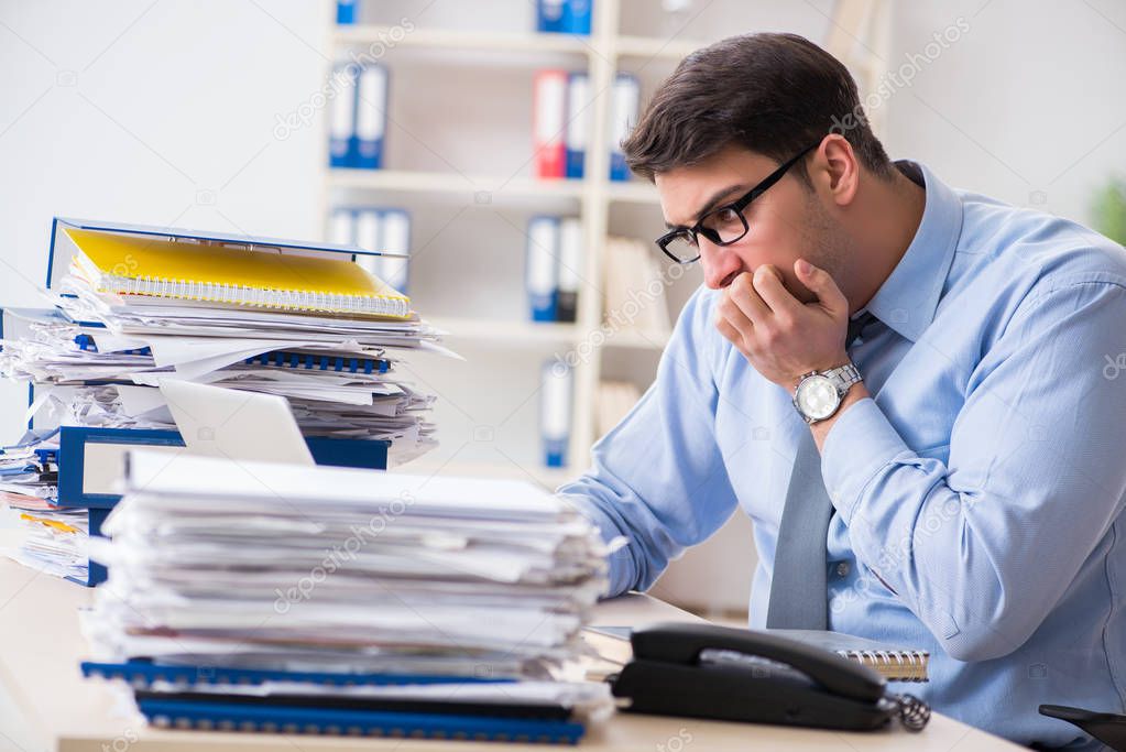 Extremely busy businessman working in office