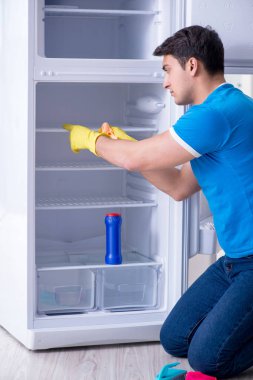 Hijyen konseptinde buzdolabını temizleyen adam.
