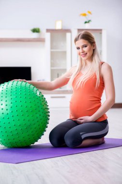 Evde doğum egzersizi yapmaya hazırlanan genç bir kadın.