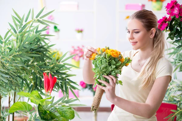 Ung kvinna vattna växter i sin trädgård — Stockfoto