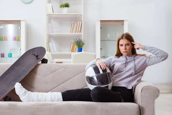 Jeune femme avec jambe cassée à la maison — Photo