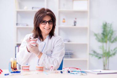 Diş implantı üzerinde çalışan kadın dişçi.